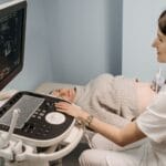 Lekarka wykonuje badanie USG ciężarnej kobiecie w gabinecie