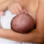 Mama karmi piersią noworodka, bliski i czuły moment więzi