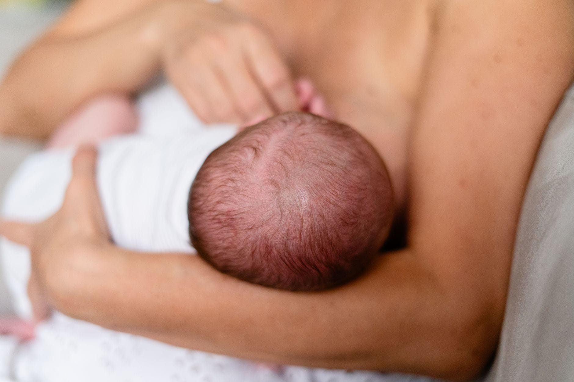 Mama karmi piersią noworodka, bliski i czuły moment więzi