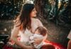 Mama karmiąca piersią niemowlę na kocu na świeżym powietrzu latem