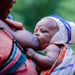 Mama karmiąca piersią niemowlę na świeżym powietrzu